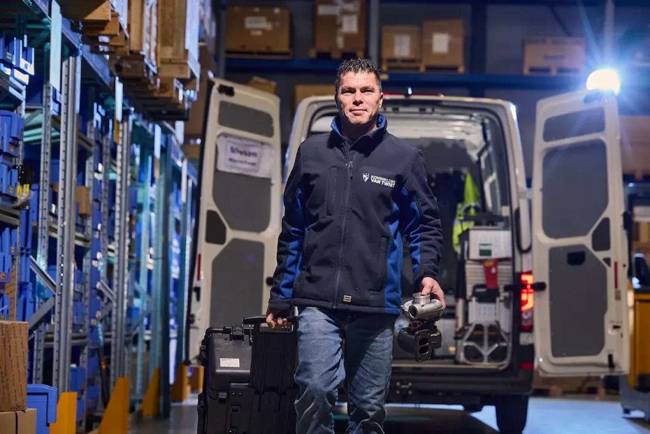 service monteur pakt onderdelen uit logistieke magazijnomgeving